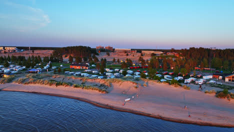 Aerial-view-following-the-shoreline-of-Kalajoki-dunes,-summer-sunset-in-Finland