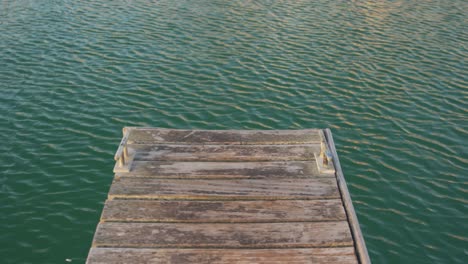 magnífica vista de un extremo de un muelle y pequeñas olas en un agua de mar tranquila
