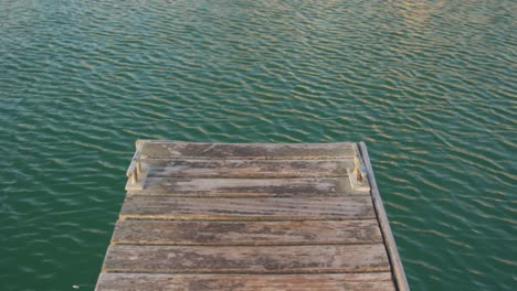 magnificent view of an end of a jetty and small waves on a calm sea water