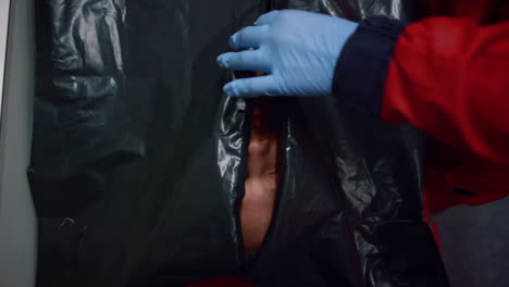 top view of medical worker hands closing black bag