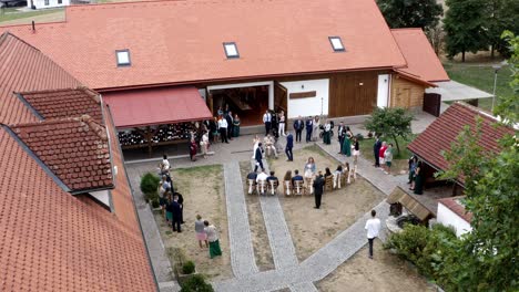 Newlywed-couple-and-guests-playing-game-at-homestead-wedding,-drone