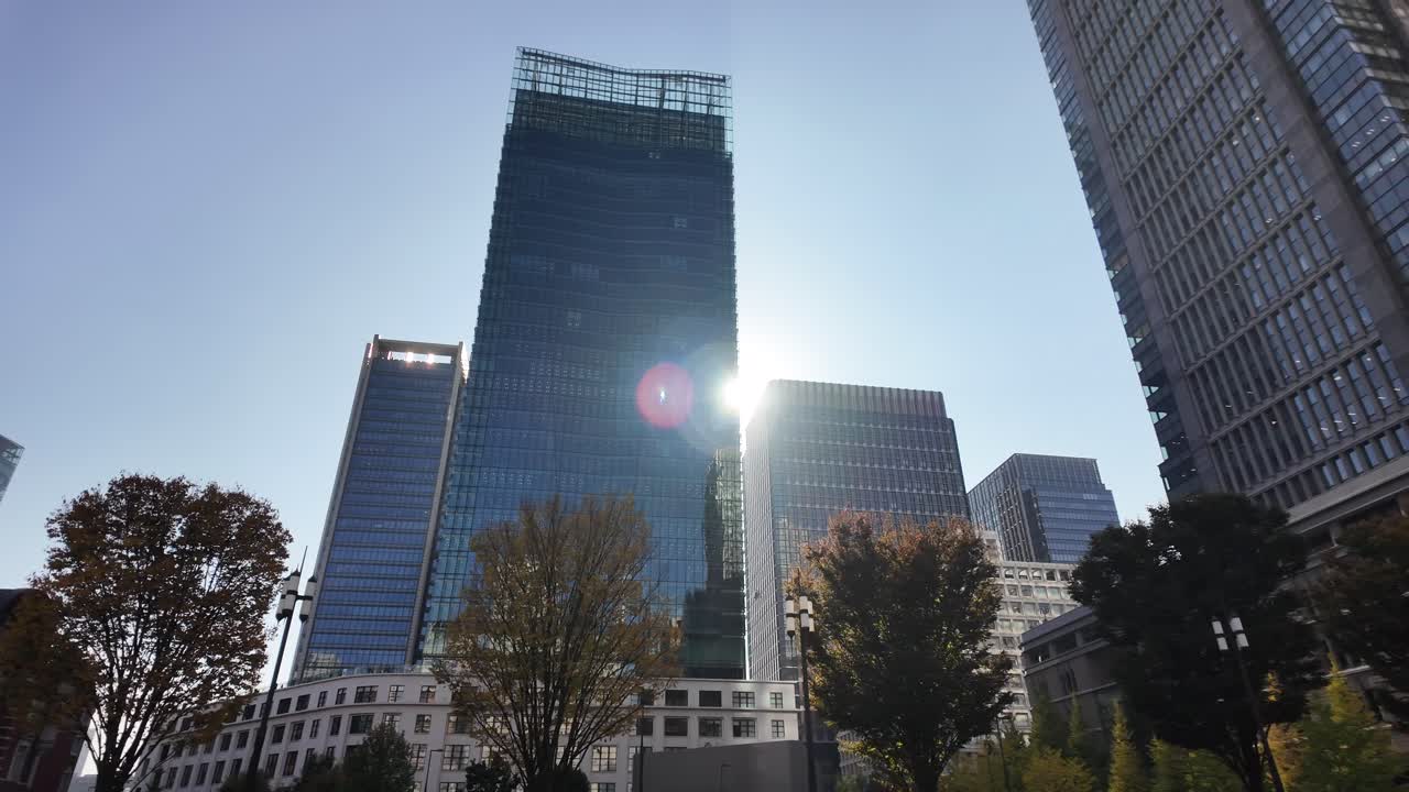 Contemporary urban environment with high-rise structures and a vibrant plaza. Pan Right Shot