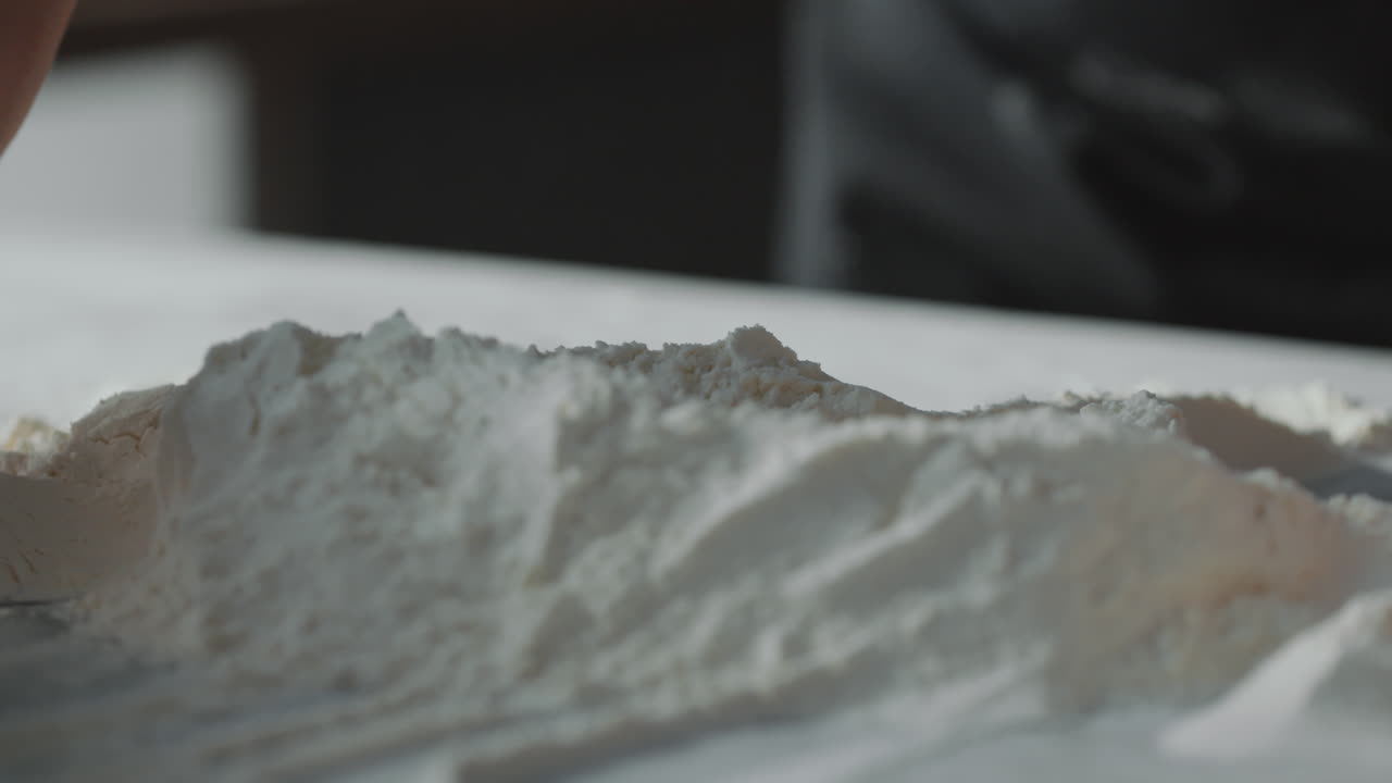 베이커 의 손 이 중앙 에 우물 이 있는 밀가루 언덕 을 형성 하고 있다