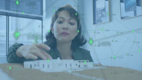 Animation-of-network-of-connections-over-asian-businesswoman-working-at-office