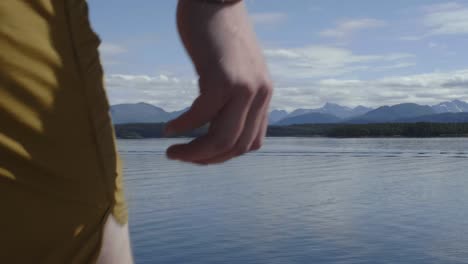 Slow-motion-shot-of-Caucasian,-long-haired,-blonde-young-male-doing-a-backflip-gainer-with-scenic-scandinavian-mountains-in-the-background-in-summer-in-Norway