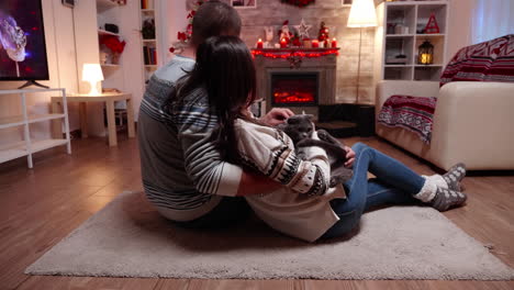 zoom in shot of couple sitting comfortable in front of fireplace