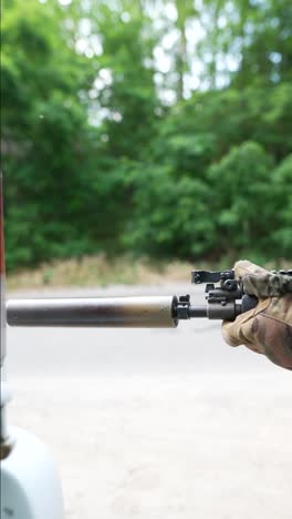 sniper rifle near a car in the woods