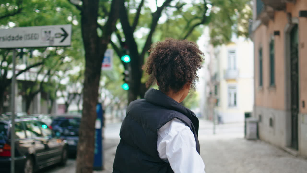 mujer feliz bailando caminando por la calle de la ciudad de cerca. chica africana moviéndose al aire libre.