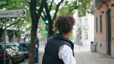 gelukkige vrouw die danst op een stadsstraat. afrikaans meisje dat naar buiten beweegt.