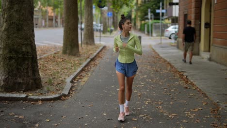 mujer corriendo en la calle de la ciudad en un día de otoño