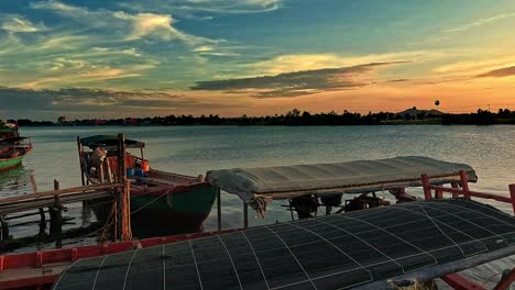 beautiful dreamy summer sunset scene of traditional khmer fishing boats moored in the riverside in kampot cambodia