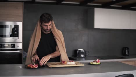 Portrait-of-a-man-serving-grapefruit-slices-on-plate-at-kitchen-in-the-morning