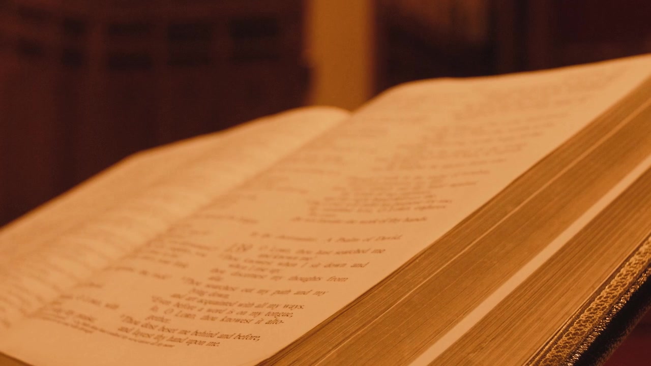 Zoom indietro da una Sacra Bibbia aperta con illuminazione calda