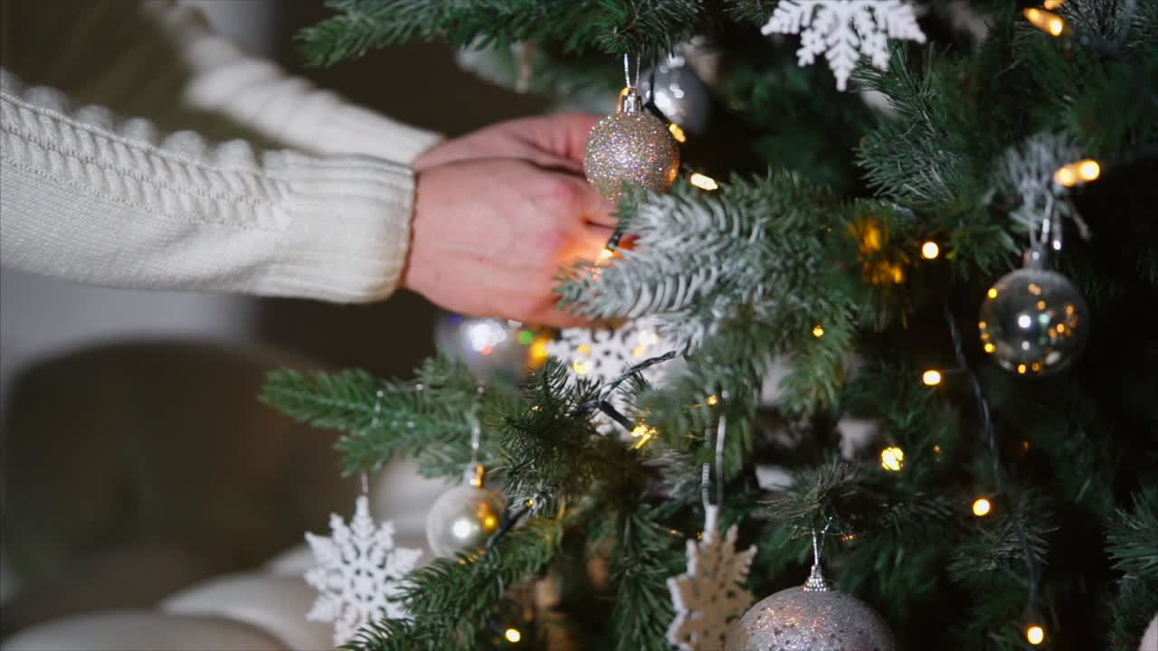 manos decorando un árbol de navidad