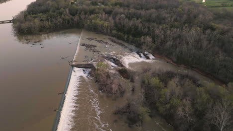 Aerial-revealing-shot-of-fast-flowing-water-through-a-waterfall-at-Lake-Sequoyah