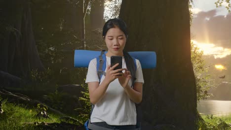 여자 는 전화 를 사용 하여 숲 에서 산책 하고 있다