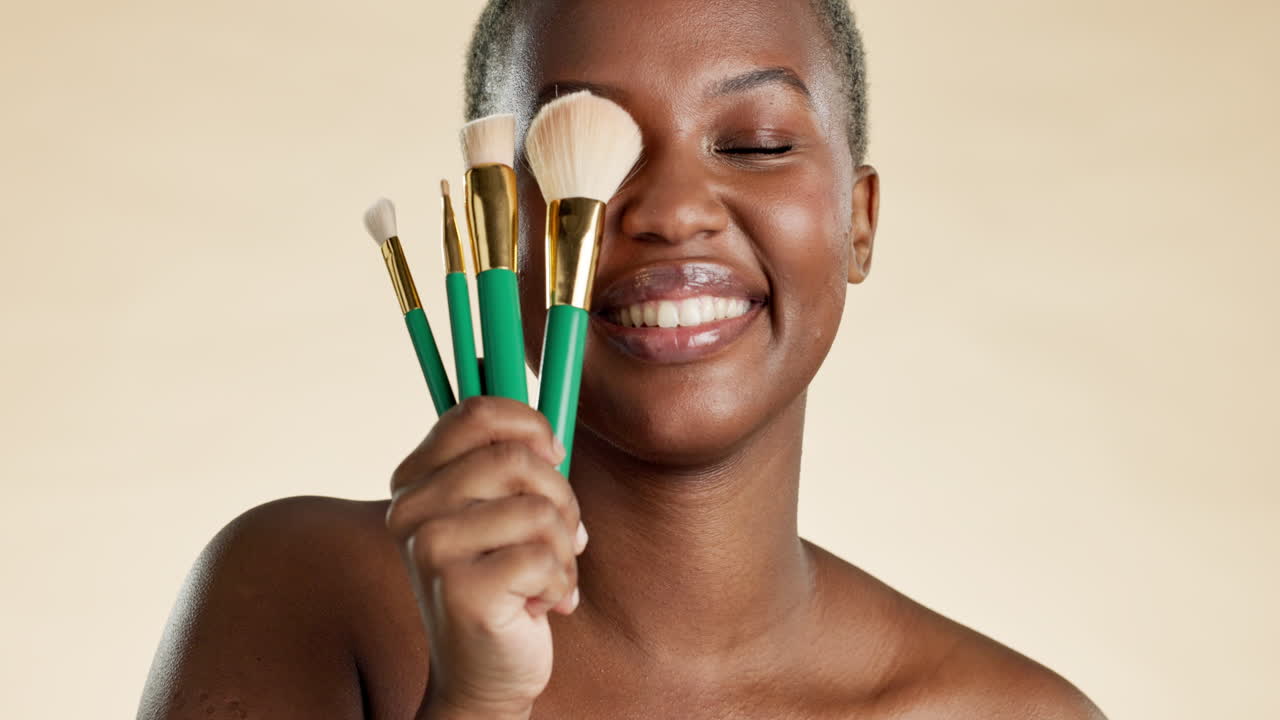 Happy, makeup and brush with black woman in studio