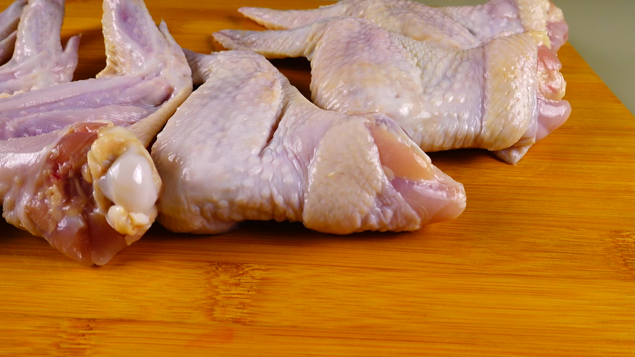 Ali di pollo fresche sono disposte su un tagliere