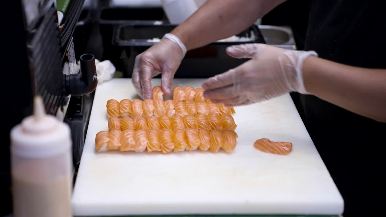 un cocinero, el chef prepara rollos de sushi en una cocina profesional