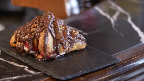 primer plano de un croissant de chocolate con relleno de fresa y plátano