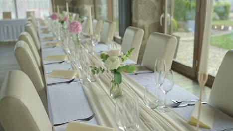 wedding tables set with dishes, cutlery, and floral decorations, meticulously prepared for the guests' lunch