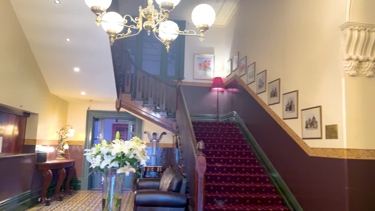 A luxurious hotel lobby with a grand staircase, elegant lighting, and classic decor in Queenscliff, Victoria, Australia