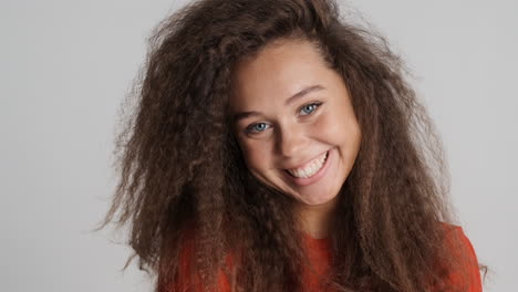 caucasian curly haired woman smiling.