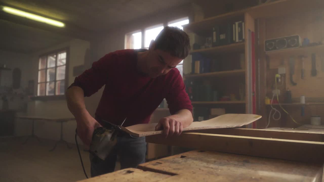 Man Sanding Wood in a Workshop