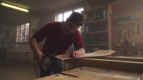 man sanding wood in a workshop