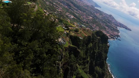 majestic cabo girao sea cliffs, lush green vegetation, coastal development, madeira, portugal. aerial drone