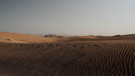 Middle-eastern-desert-landscape-near-Dubai-in-the-United-Arab-Emirates-with-distant-mountains
