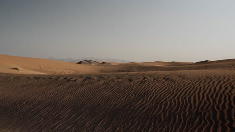 Paisaje-Desértico-Del-Medio-Oriente-Cerca-De-Dubai-En-Los-Emiratos-árabes-Unidos-Con-Montañas-Distantes