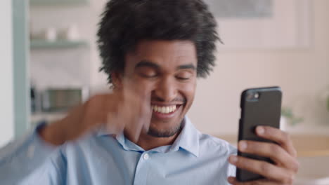 attractive mixed race man having video chat using smartphone at home showing off hairstyle chatting sharing lifestyle enjoying online communication