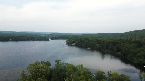 Push-in-tree-foreground-protects-calm-secluded-portion-of-lake-on-windy-cloudy-day