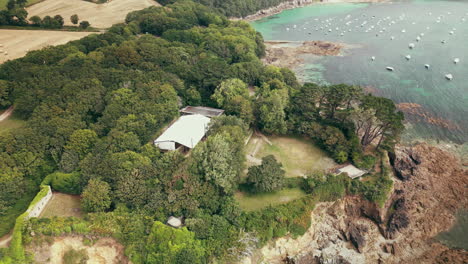 dolly and tilt aerial view of a large body of water, ruined castle and large marquee