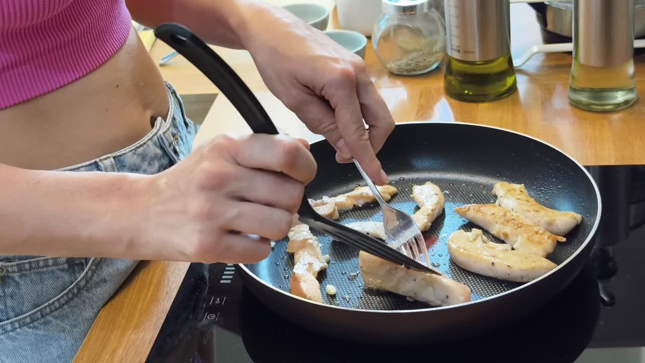 Mujer cocinando tiras de pollo en una sartén