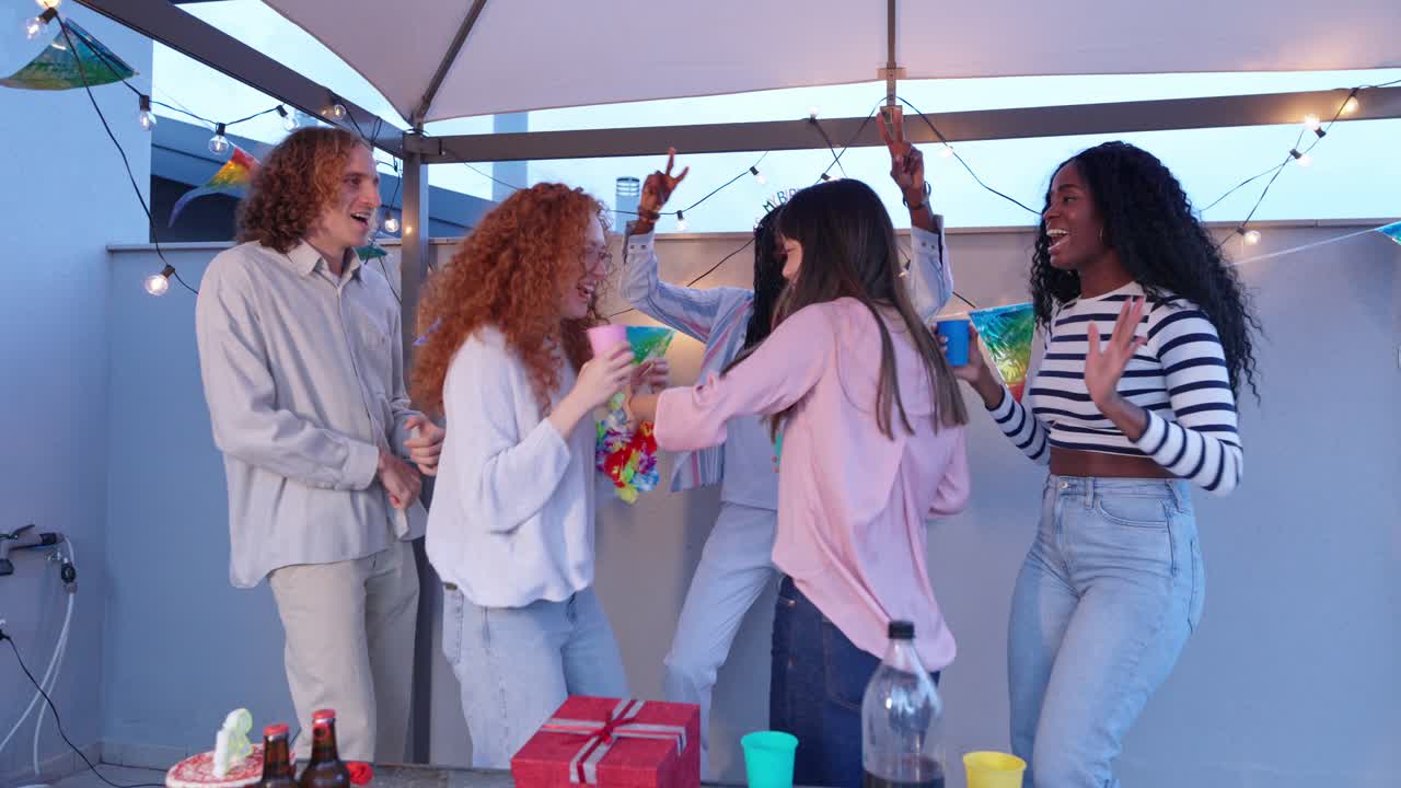 Group of friends celebrating birthday on rooftop party