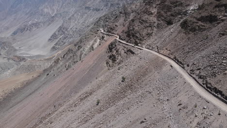 Aerial-View-of-Dirt-Road-on-Hillside-in-Highlands-of-Northern-Pakistan,-Drone-Shot