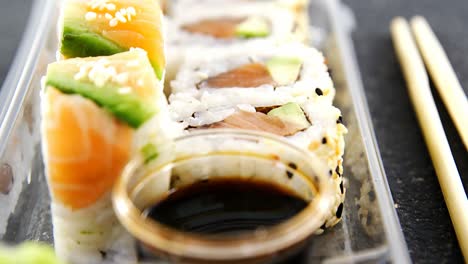 Plastiktablett-Mit-Verschiedenen-Sushi-Rollen-Mit-Lachs