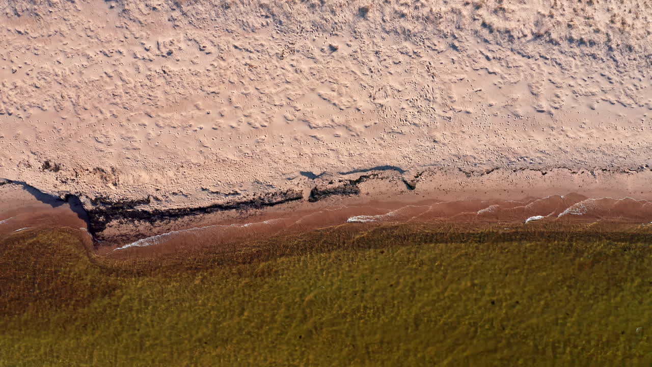 возвышающийся над береговой линией с волнами, медленно бьющимися о песчаный пляж