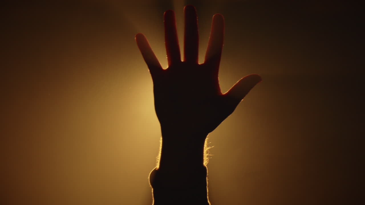 Open Hand closing Power Gesture Silhouette Hand Closing in studio golden Light