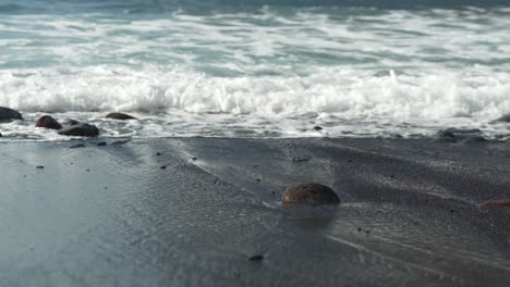 olas del mar lavando playa de arena y pequeños guijarros en ella, vista de bajo ángulo