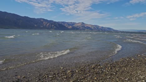 waves on the rocky shore of lake hawea in otago region, south island, new zealand - wide shot
