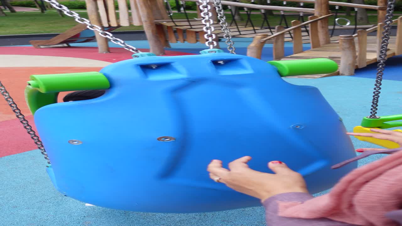 niños jugando en un columpio en un patio de recreo