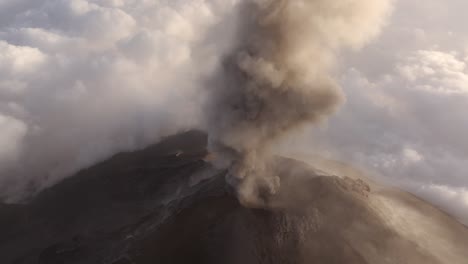 vista aérea alrededor de una enorme nube de humo que se eleva desde un cráter volcánico activo