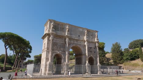 arch of constantine with tourists walking by on sunny clear day with blue skies