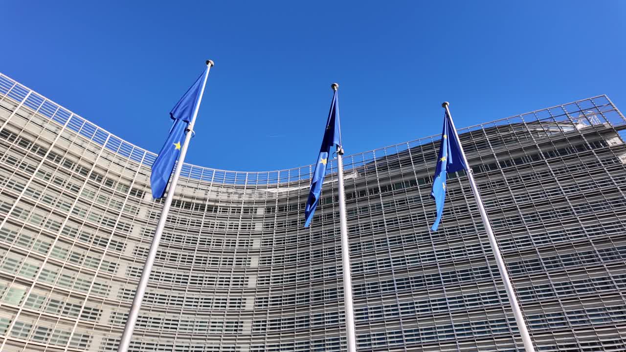 European Union flags waving at the Berlaymont building in Brussels