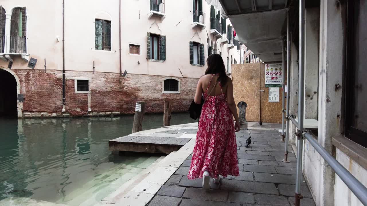 Back View Of A Female In Dress Walking On Esplanade In Venice, Italy