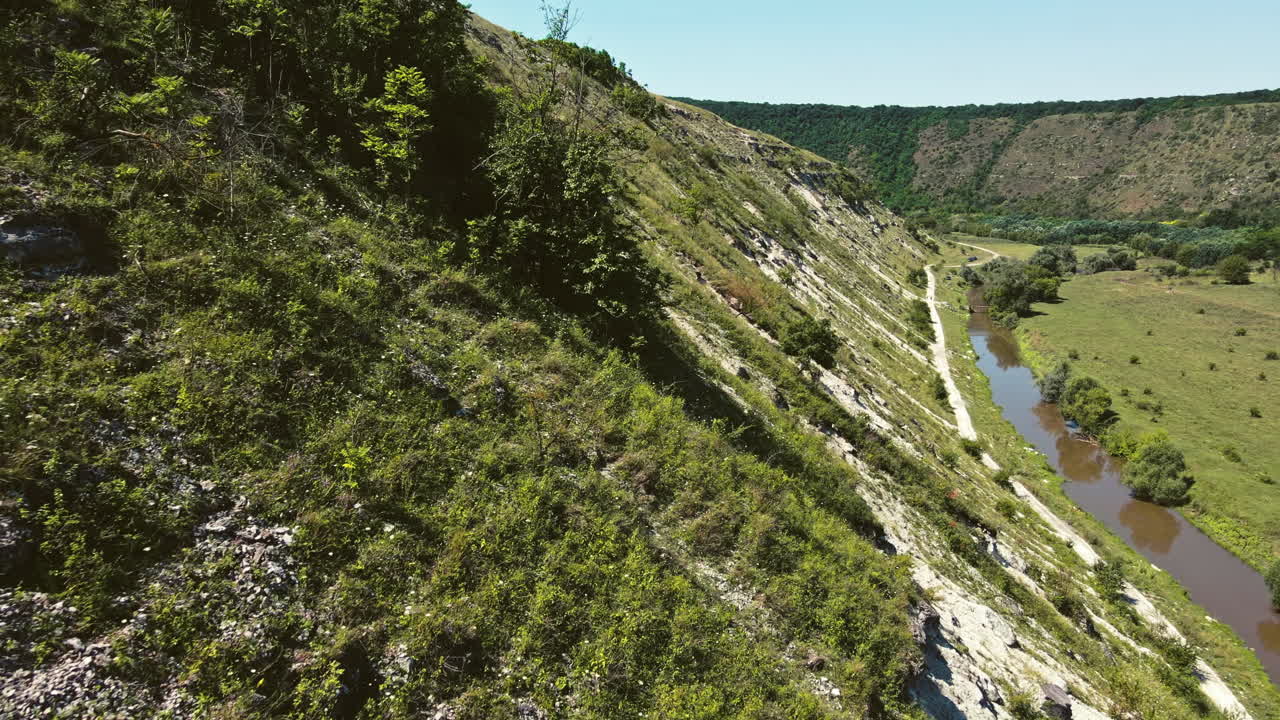 Aerial drone view of nature, Moldova. Rocky hill slope in a valley with greenery and river