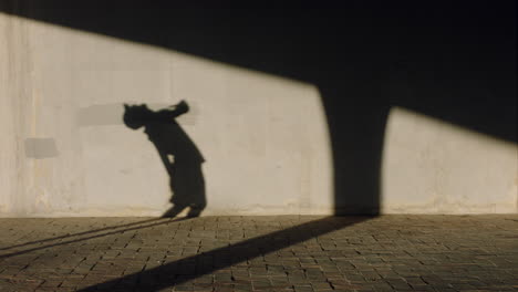 hombre bailando sombra de un joven bailarín de break realizando varios movimientos de baile de estilo libre adecuado hombre de raza mixta practicando en la ciudad al atardecer